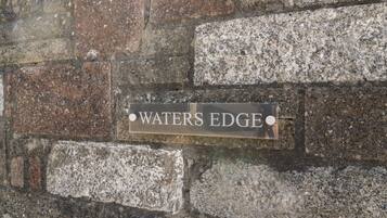 Et skilt på en stenvæg med teksten 'WATERS EDGE'.