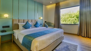 Quarto de hotel moderno com uma cama grande, uma escrivaninha e uma cadeira.