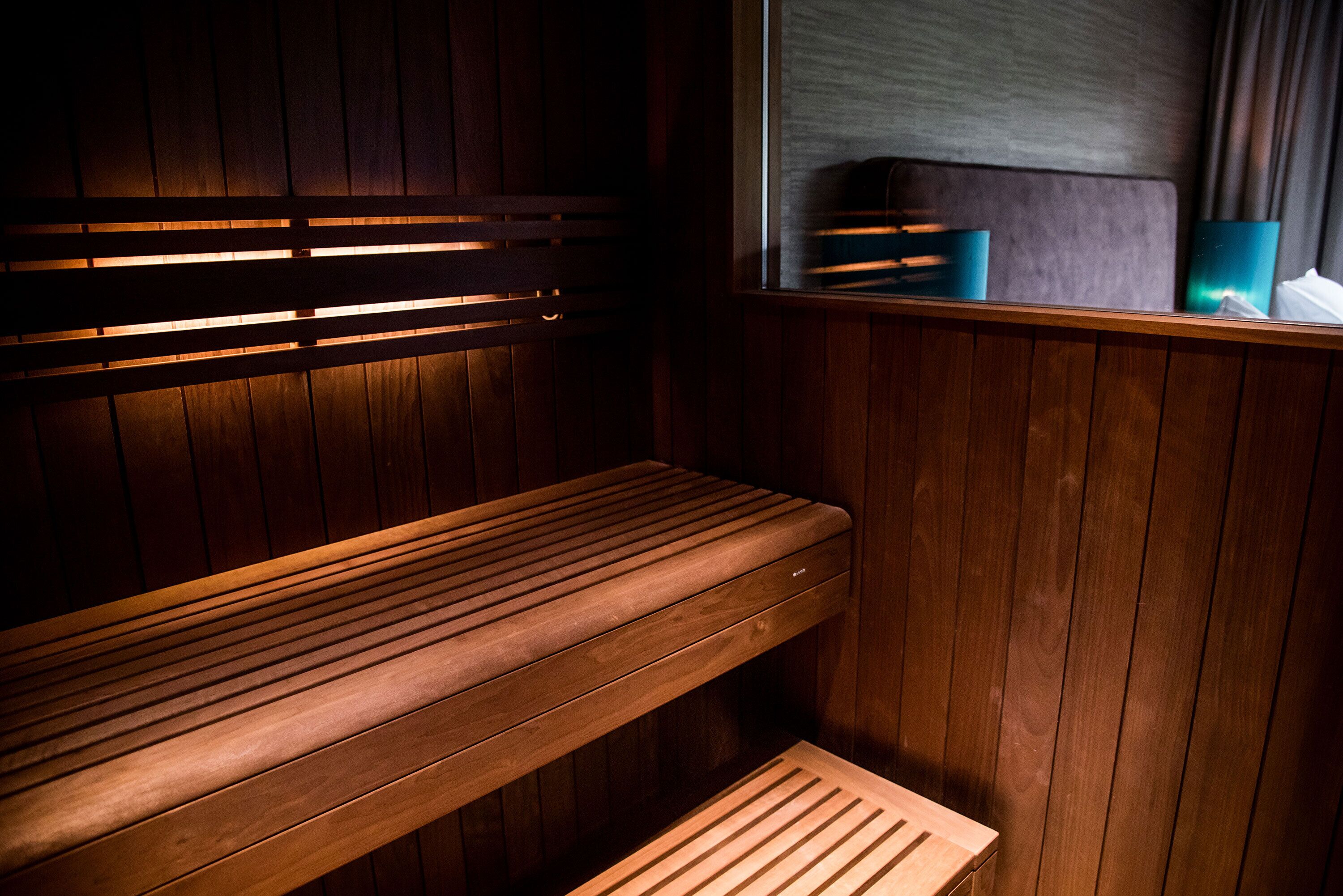 A wooden bench in a room with wooden walls and a window.