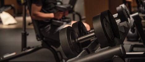 A gym with exercise equipment, including dumbbells and a punching bag.