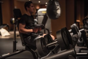 A gym with exercise equipment, including dumbbells and a punching bag. - Billingehus (Skovde)