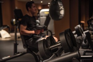 Un gimnasio con equipo de ejercicio, incluyendo mancuernas y un saco de boxeo.
