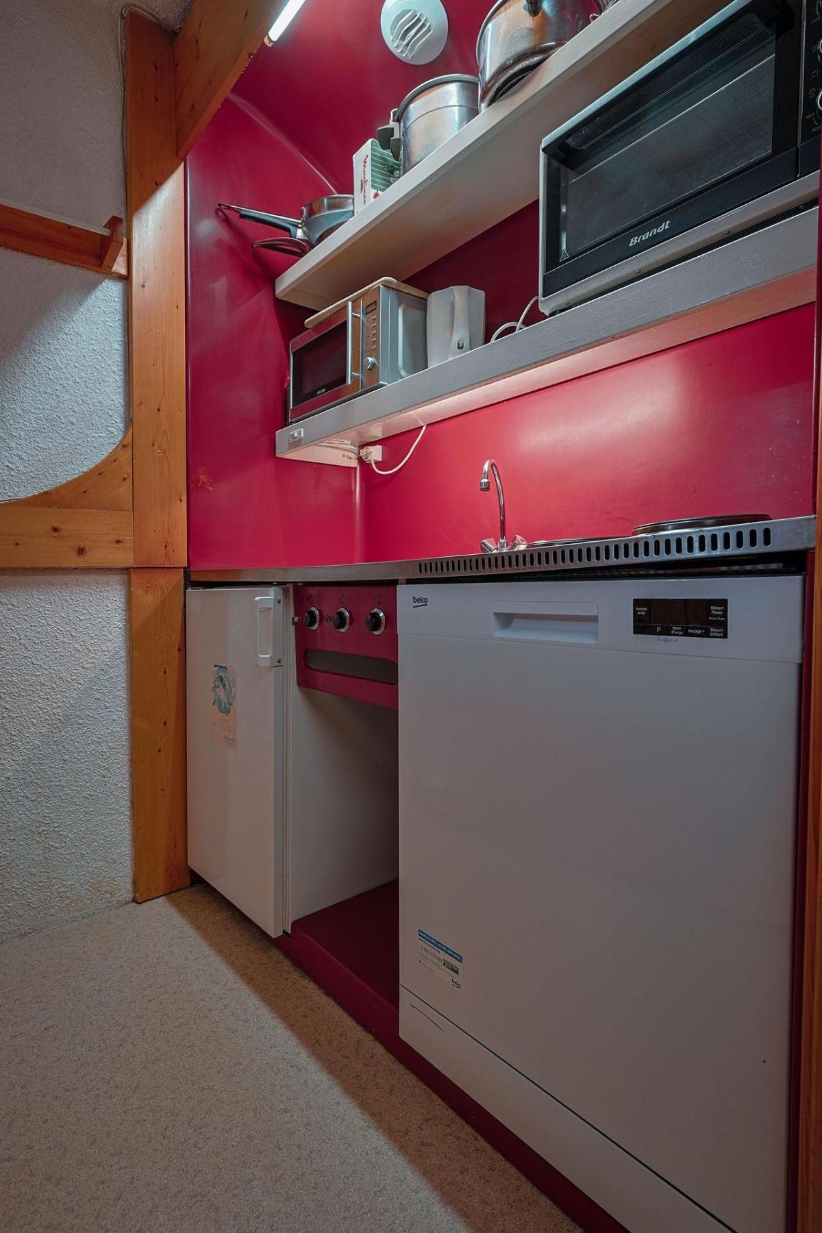 Una cocina compacta equipada con microondas, horno y refrigerador.