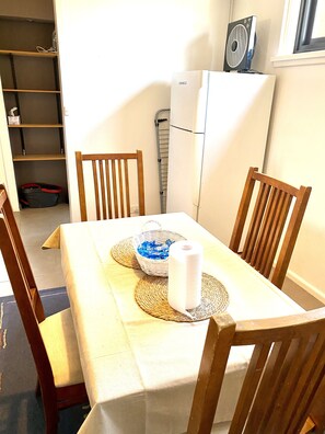 Enjoy meals in this cozy dining area with a table set for two, featuring a tablecloth and two chairs.