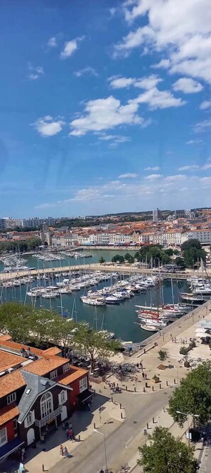 A marina with boats docked, a waterfront promenade, and buildings in the background. - Spacious and charming 2-room apartment in the city center (La Rochelle)