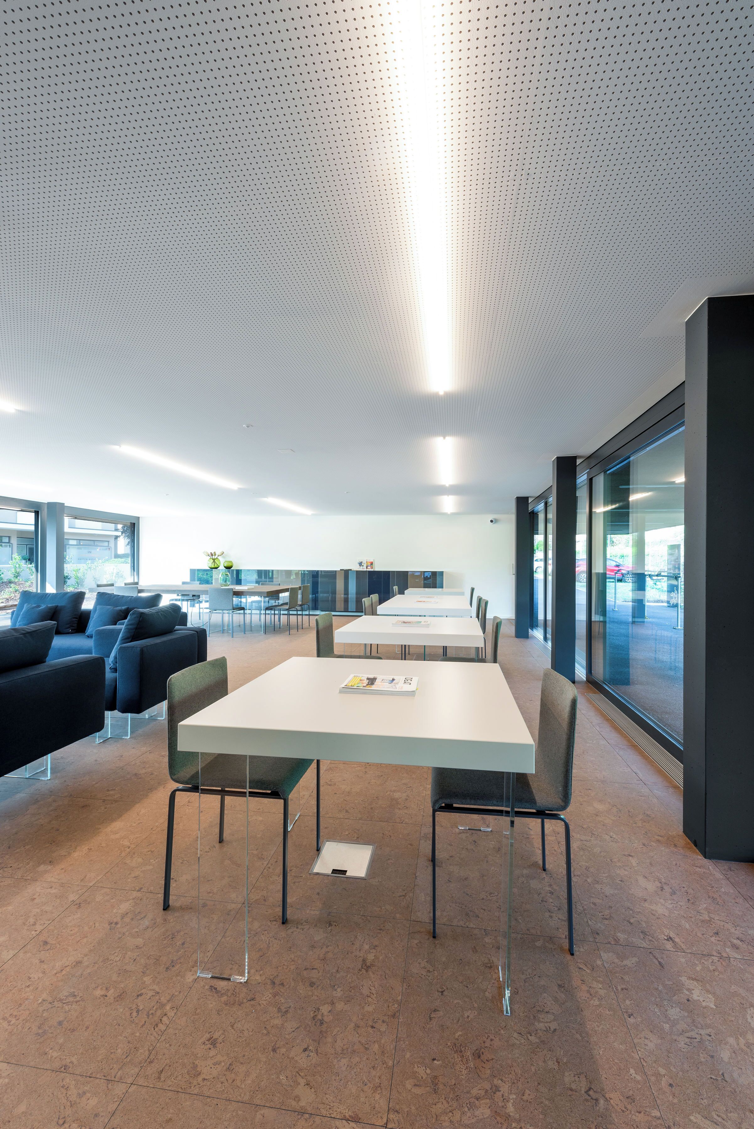 Ein moderner Konferenzraum mit langem Tisch, Stühlen und Sofas.