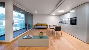 A modern kitchen with a dining area, a sofa, and a large window. - Lo Scudo di Stabio (Stabio)
