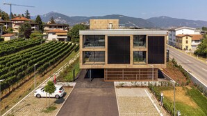 A modern building with a flat roof, large windows, and a paved entrance. - Lo Scudo di Stabio (Stabio)