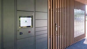 A metal security door with a keypad and a small window displaying a sign. - Lo Scudo di Stabio (Stabio)