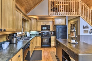 Enjoy cooking in this well-equipped kitchen with a microwave, oven, and refrigerator, plus ample countertop space and a coffee station.