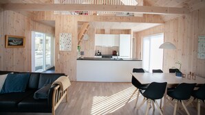 A wooden interior with a dining area, kitchen, and a staircase. - Vacation Home - Scenic Nature - Sandoy (Sandur)