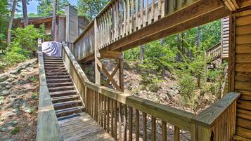 Un escalier en bois mène à un chalet entouré d’arbres.