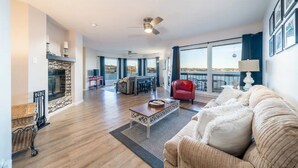 Een ruime woonkamer met een open haard, een eethoek en een balkon met uitzicht.