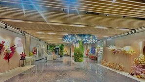 A modern hotel corridor with a polished marble floor, decorative floral arrangements, and a contemporary ceiling design. - Hengsheng Kejia Courtyard (Xinfeng)