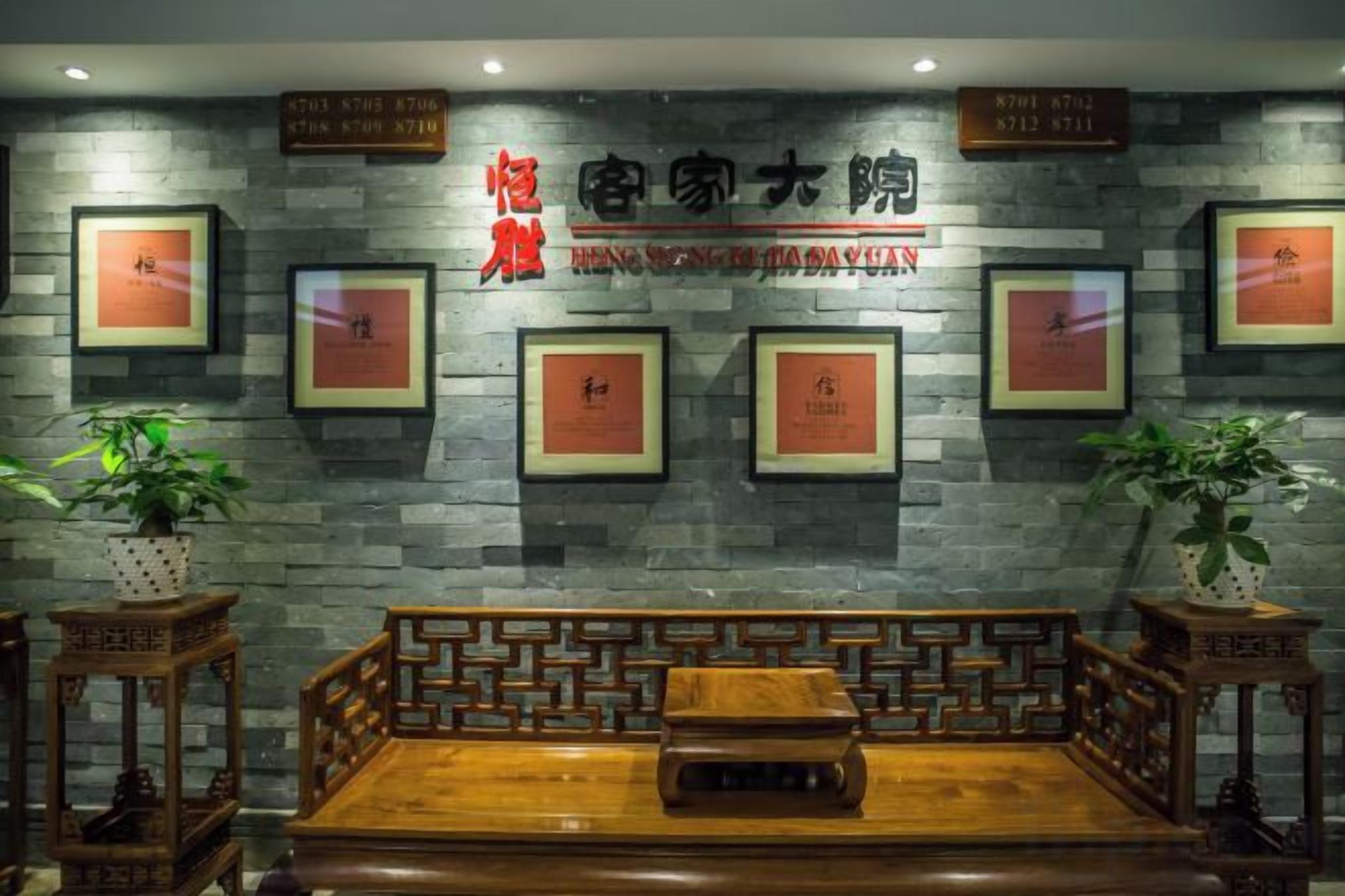A reception area with a reception desk, framed certificates on the wall, and potted plants.