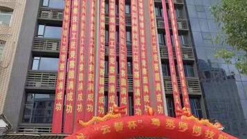 A building with vertical banners and a red archway with text.