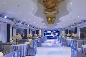 A spacious banquet hall with round tables, grey chairs, and floral centerpieces. - Hengsheng Kejia Courtyard (Xinfeng)