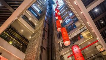 A multi-level atrium with a central column, glass railings, and a modern interior design.