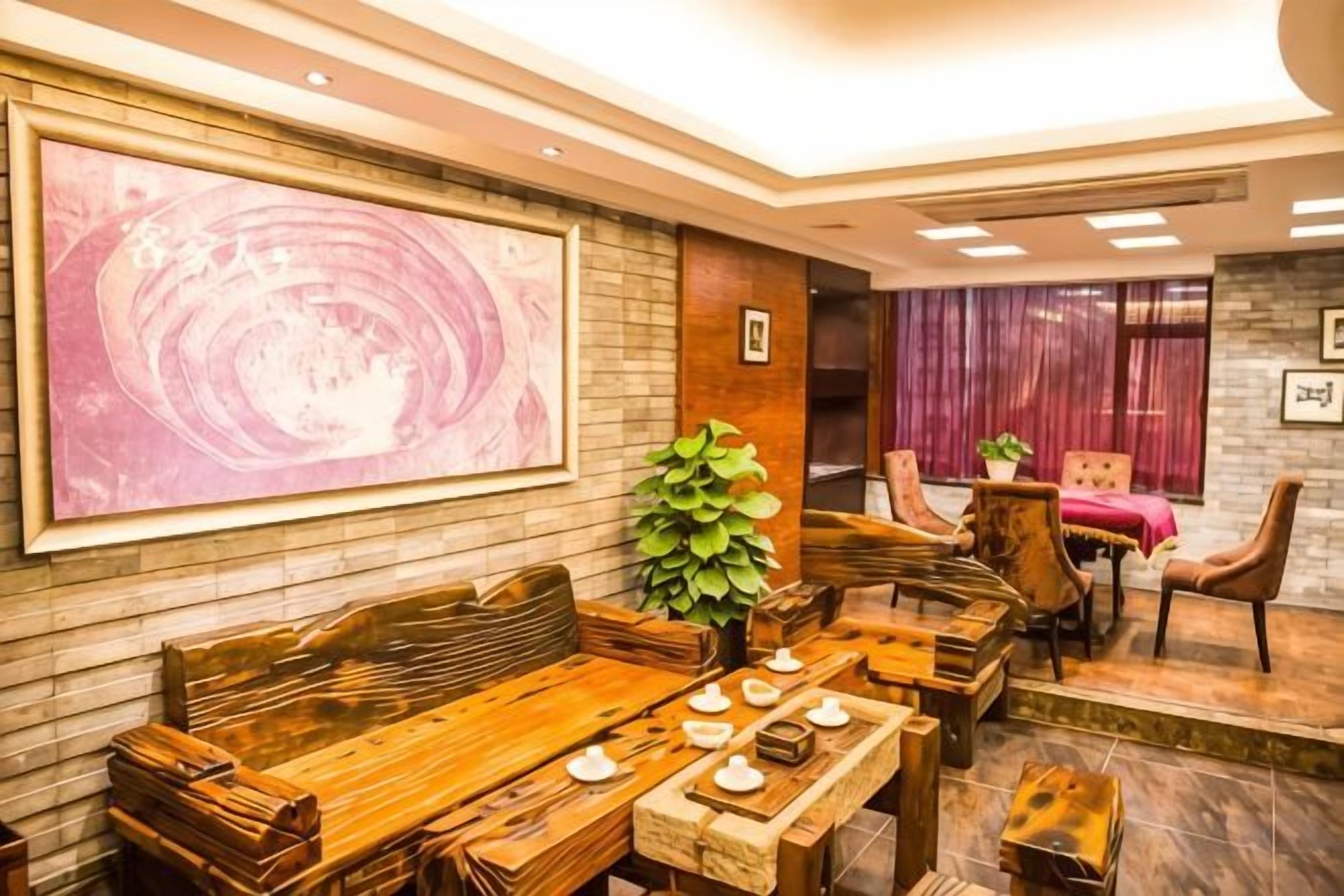 A dining area with a long wooden table, chairs, and a large abstract painting on the wall.