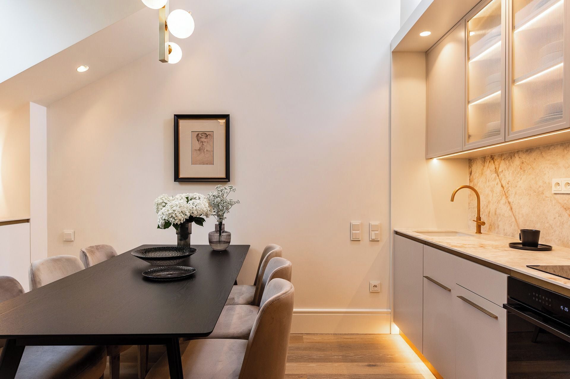 A modern kitchen with a marble countertop, a built-in oven, and a dishwasher.