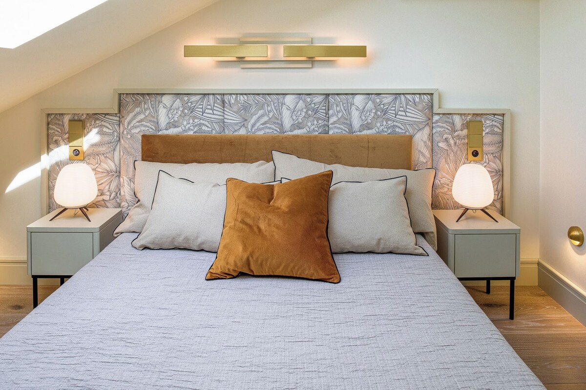Een slaapkamer met een groot bed, twee nachtkastjes en een dakraam.