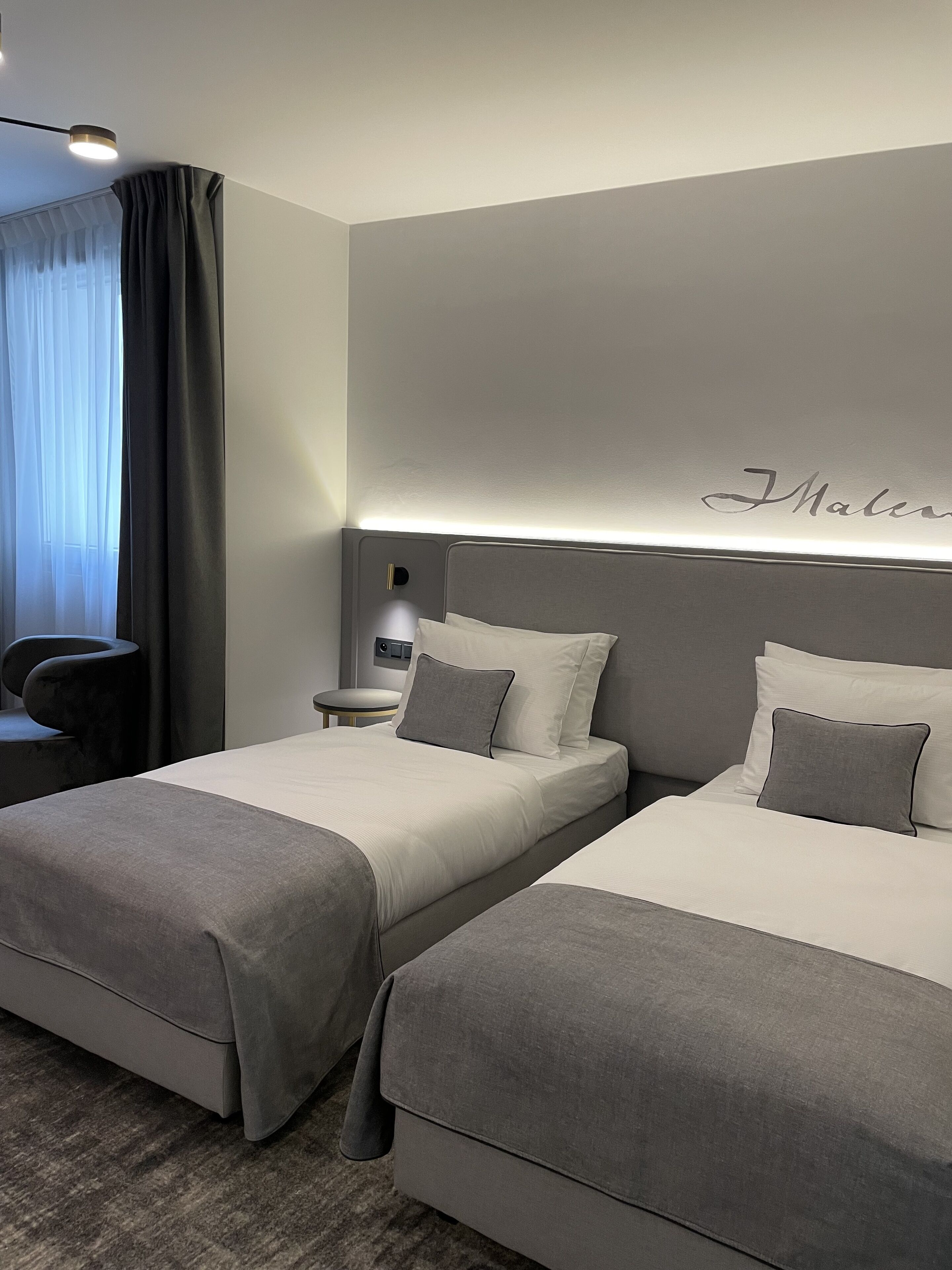 Una habitación de hotel moderna con dos camas, un escritorio y una silla.