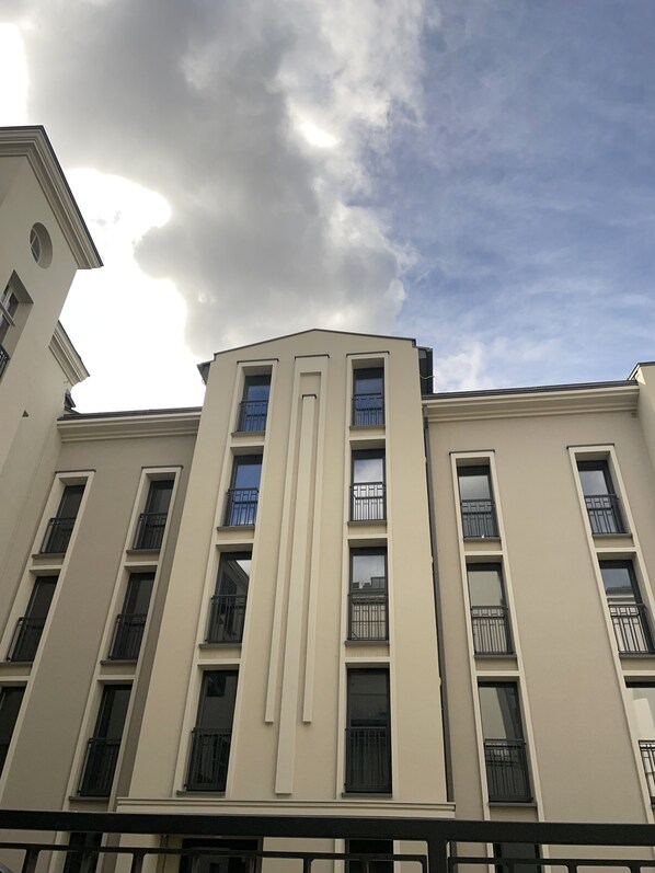 Een meerlaags gebouw met een platte gevel, grote ramen en balkons.