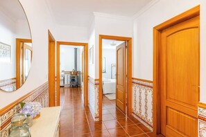 A hallway with a marble counter, wooden doors, and tiled flooring. - Casa da Leira (Vila Nova de Cerveira)
