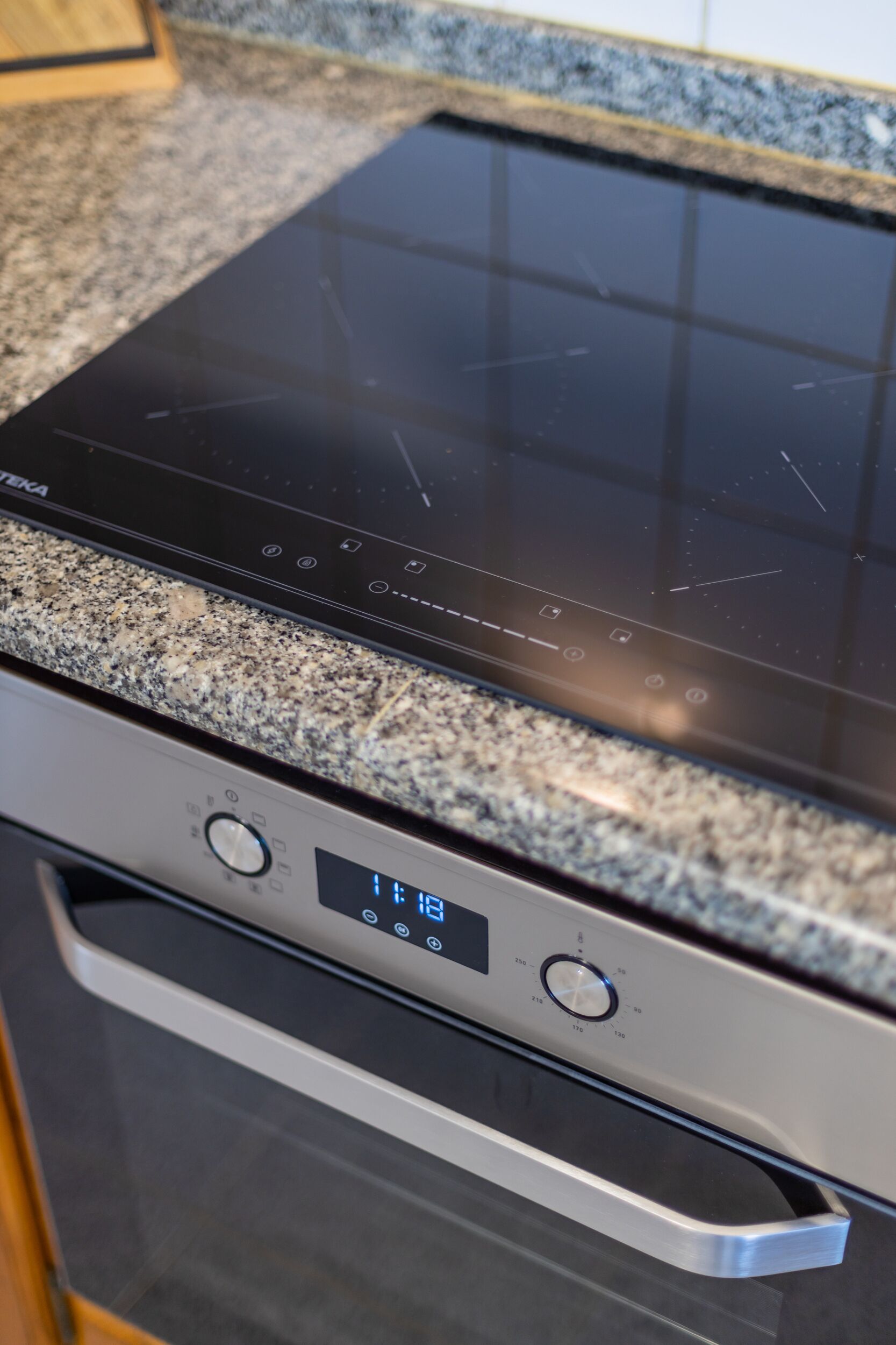 Una cocina con placa vitrocerámica y horno integrados.