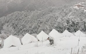 A row of snow-covered tents in a mountainous area. - Camp Awara Dhanaulti (Dhanaulti)