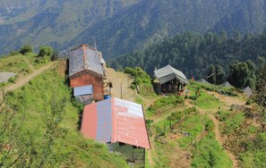 A mountainous area with a small building labeled "CHAMP" and a tented structure. - Camp Awara Dhanaulti (Dhanaulti)