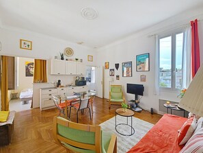 A compact living space with a kitchenette, dining area, and a bed.