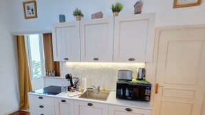 A compact kitchen with white cabinetry, a built-in microwave, and a small countertop. - HENRI CAMILLE REAL ESTATE - Florida 2 - 2 bedrooms close center (Cannes)