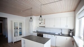 A modern kitchen with white cabinetry, a black countertop, and pendant lights. - 3BR - Townhouse - Free Parking -Tórshavn (Hoyvík)