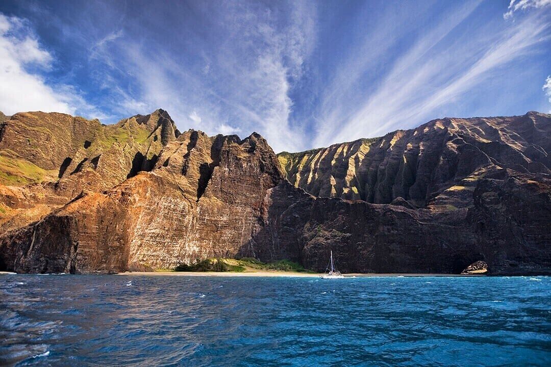 A coastal landscape with rocky cliffs and a clear blue sea.