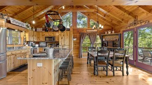 A spacious kitchen with wooden cabinets, a granite countertop, and hanging pots. - 🌄Sleeps up to 16 🌄 Pristine Mountain Views from Downtown Helen ⛰️ (Helen)