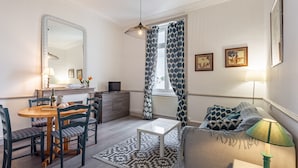 Een woonkamer met een eethoek, een bank, een salontafel en een televisie.