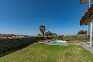 A backyard with a swimming pool, lounge chairs, and a wooden deck. - Via Mare - Apt avec splendide vue (Grosseto-Prugna)