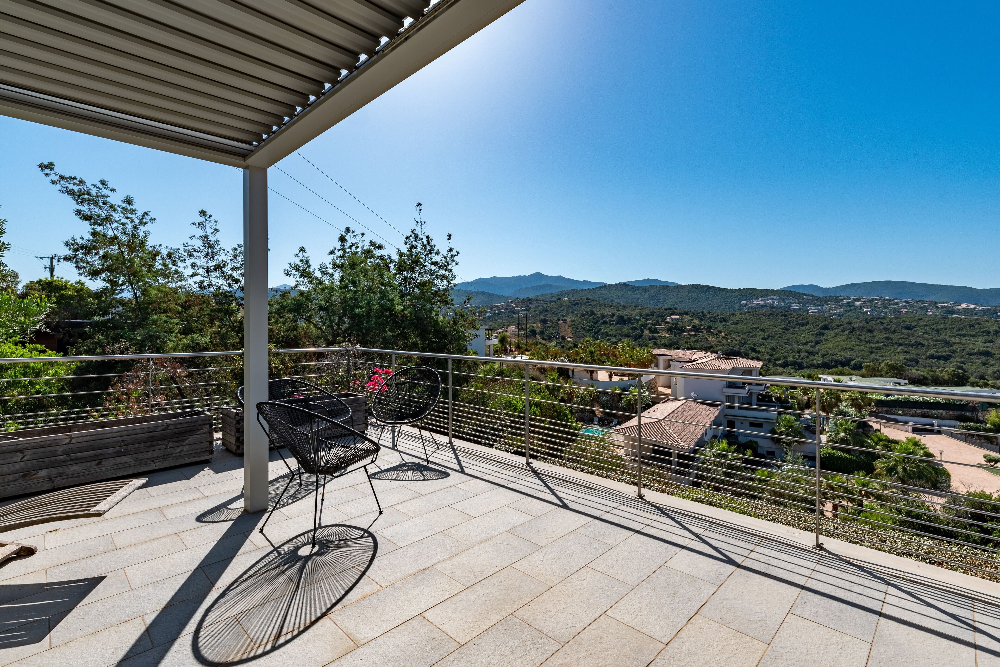 Eine Terrasse mit Blick auf Berge und eine Stadt.