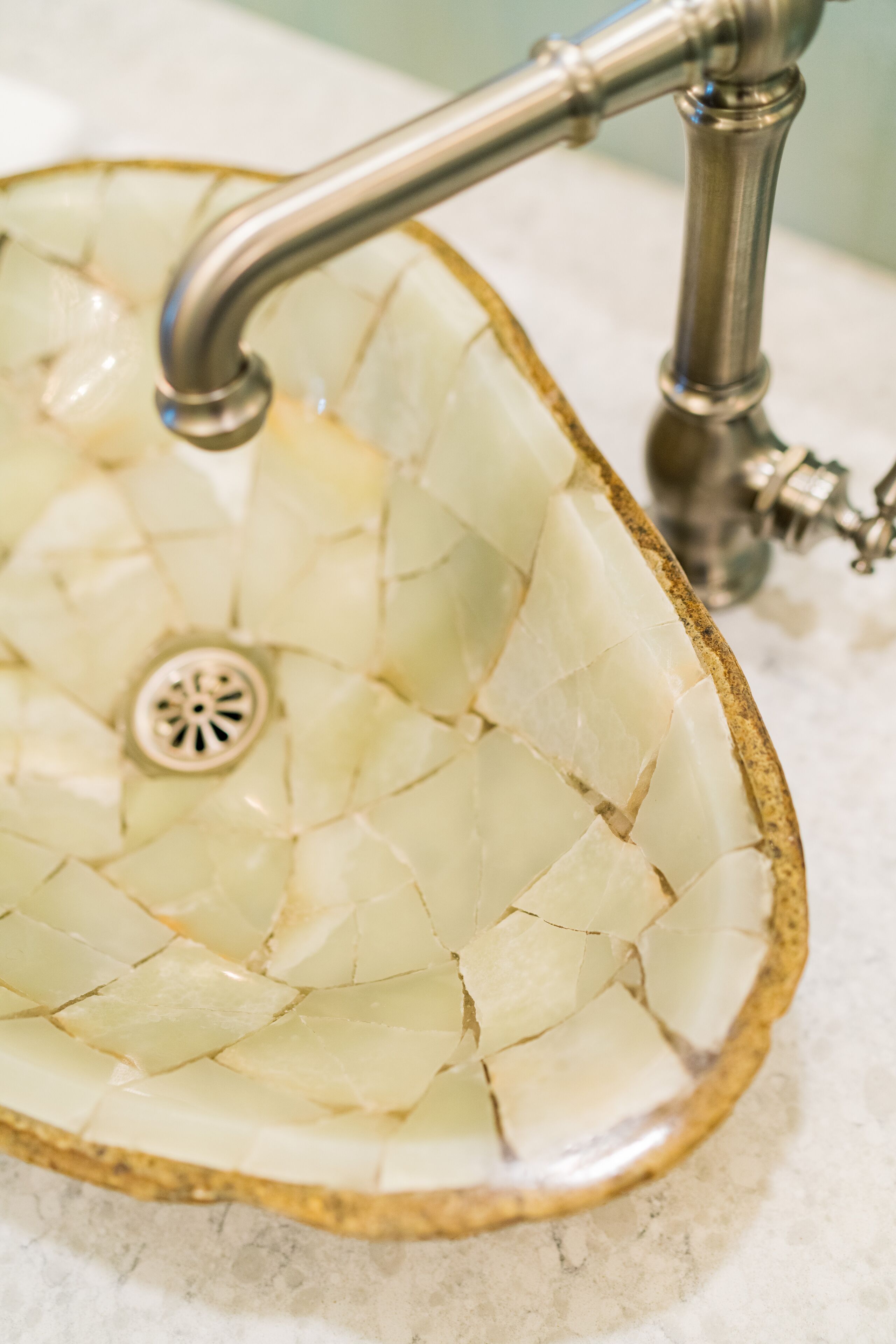Un lavandino con decorazione a mosaico e un rubinetto.