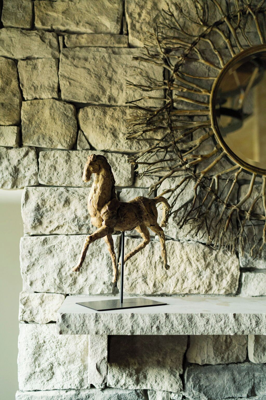 Una chimenea de piedra con una escultura de un caballo.