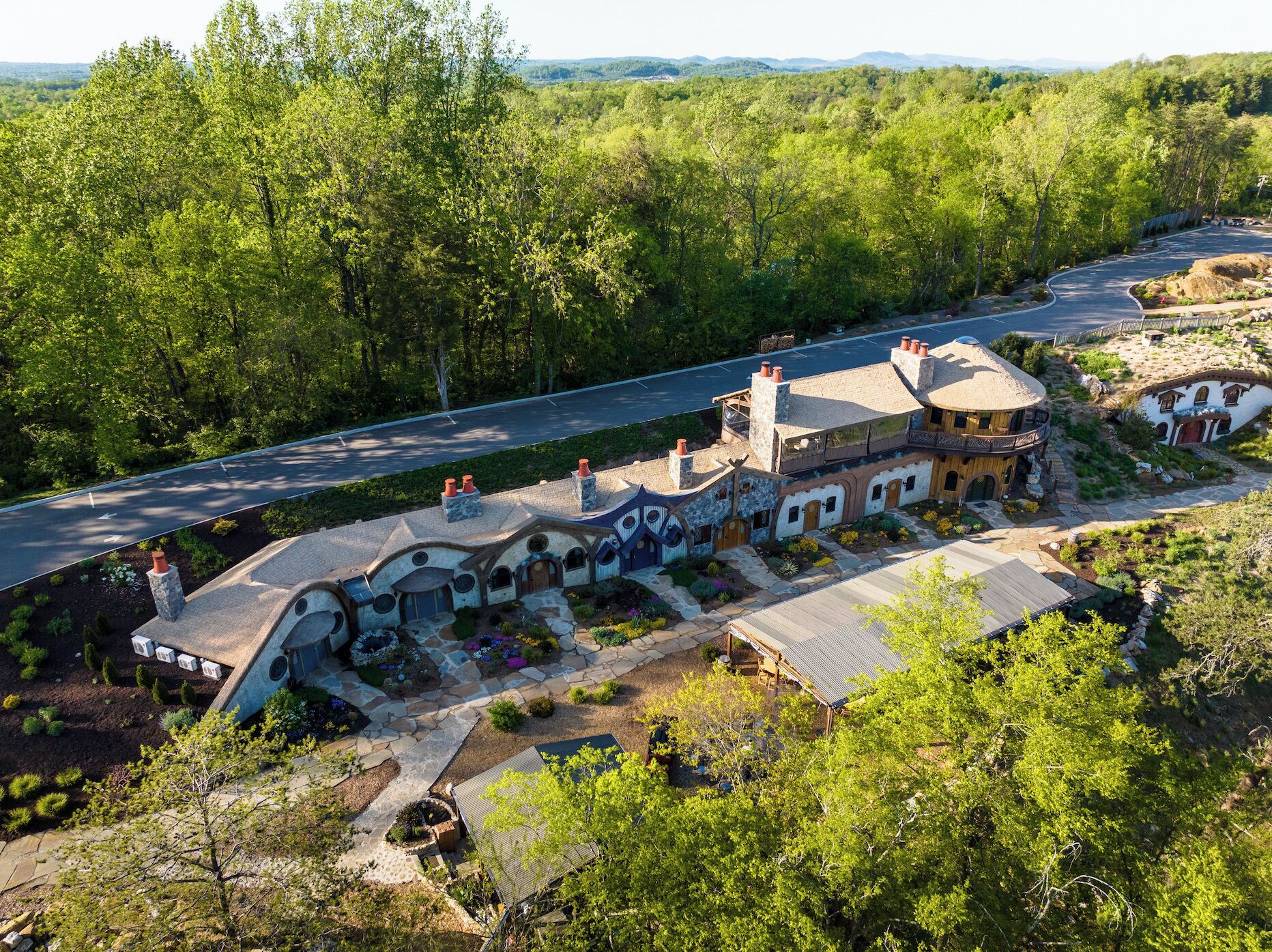 A large, rustic house with multiple chimneys and a stone pathway leading to the entrance.