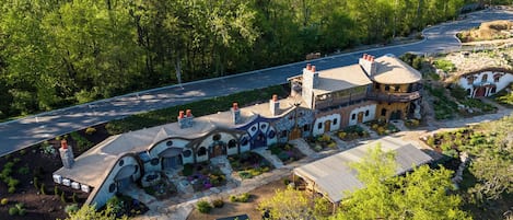 A large, rustic house with multiple chimneys and a stone pathway leading to the entrance.