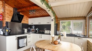 A compact kitchen with white cabinets, a microwave, a coffee maker, and a sink. - Ty Coed - 63 (Blaenau Ffestiniog)