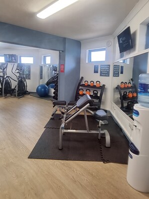 A gym with exercise equipment, a water dispenser, and a mirror. - 3 Bedroom Static Caravan, Hoburne Devon Bay (Paignton)