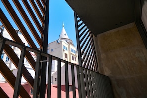 A view through a metal railing with a building featuring a dome and a spire in the background. - Galata Rasso Boutique Hotel (Istanbul)
