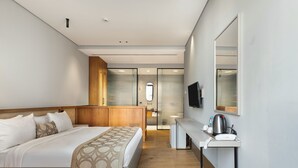 A modern hotel room with a large bed, a desk with a coffee maker, a TV, and a glass shower area. - Galata Rasso Boutique Hotel (Istanbul)