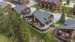 A residential complex with multiple two-story houses, each featuring a balcony and a covered outdoor seating area. - Chateau Lawrence | Pool Table | Kids` Gaming Room (Fairmont Hot Springs)
