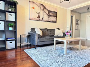 Relax in this stylish living room with a sofa, coffee table, and shelving unit, perfect for unwinding.