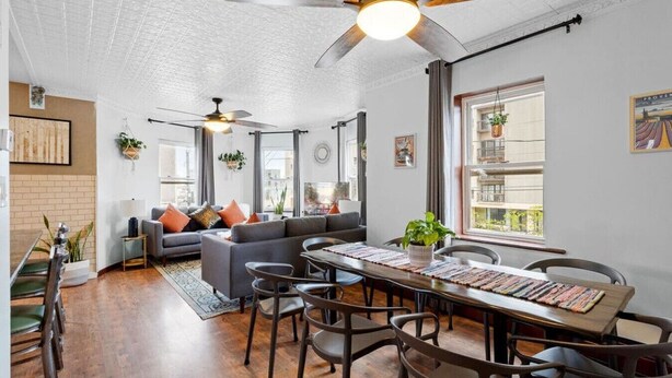 A spacious living area with a dining table, multiple chairs, a sofa, and ceiling fans. - Unique 5BD/3BA near Hard Rock, Ocean & Boardwalk (Atlantic City)